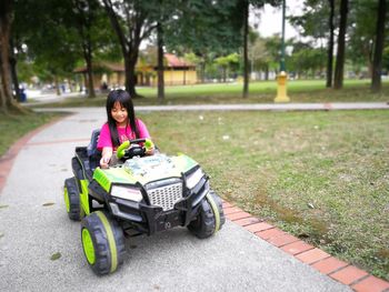 Girl riding beach buggy on footpath at park