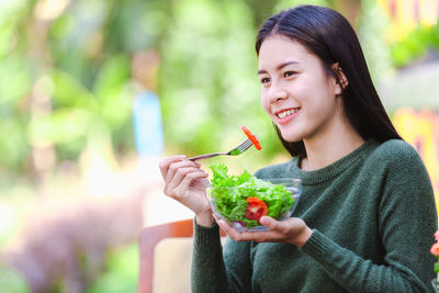 Portrait of a smiling young woman holding drink