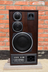 Close-up of telephone booth on brick wall