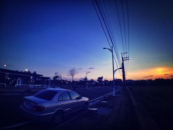 Electricity pylon against sky at sunset