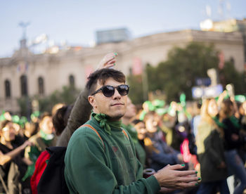 Portrait of man using mobile phone in city