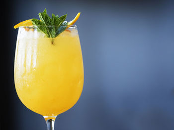 Close-up of lemonade with sea buckthorns and ice against wall