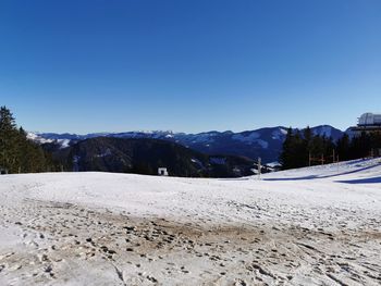 Scenic view of snowcapped mountains against clear blue sky