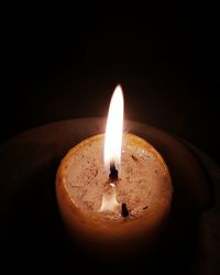 Close-up of illuminated candle against black background