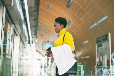 Side view of young man using mobile phone