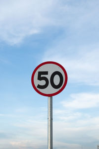 Low angle view of road sign against sky