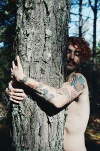 Man standing on tree trunk in forest