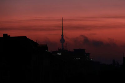 Silhouette of buildings against orange sky