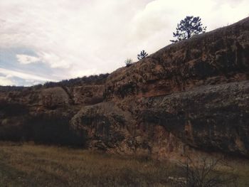Low angle view of rocky mountain against sky