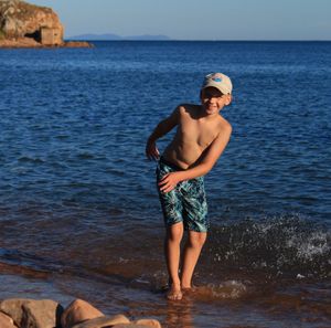 Shirtless man standing in sea