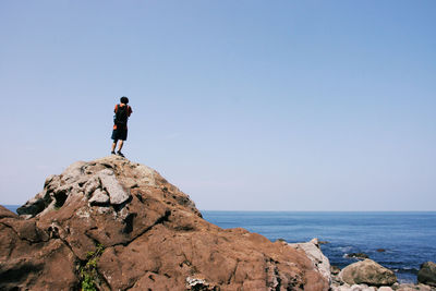 Rear view of man standing on cliff