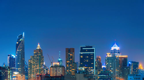 Illuminated buildings in city against sky