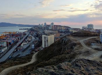 High angle view of buildings by sea against sky during sunset