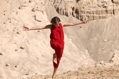 Rear view of woman with arms raised