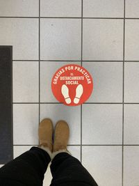 Low section of person standing on tiled floor