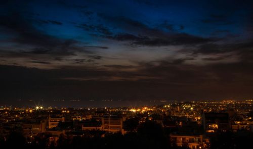 Aerial view of illuminated cityscape against sky at night