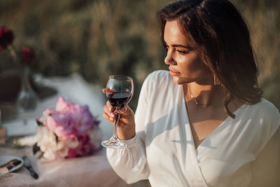 Midsection of woman drinking glass