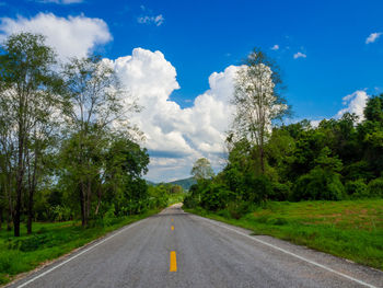 Road amidst trees against sky