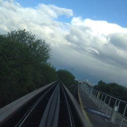 Railroad track against cloudy sky