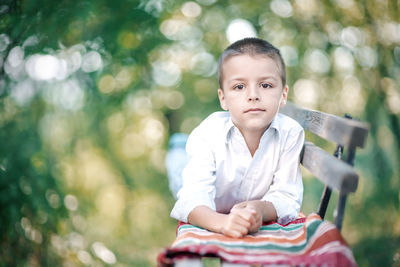 Portrait of boy sitting on bench