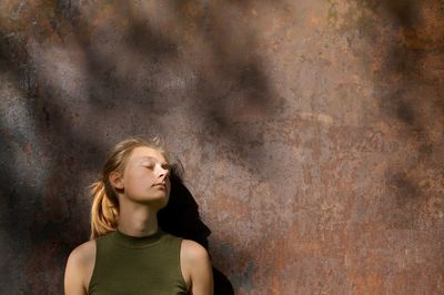 Young woman standing on wall