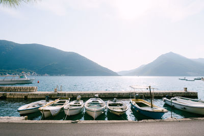 Boats moored at lake against sky