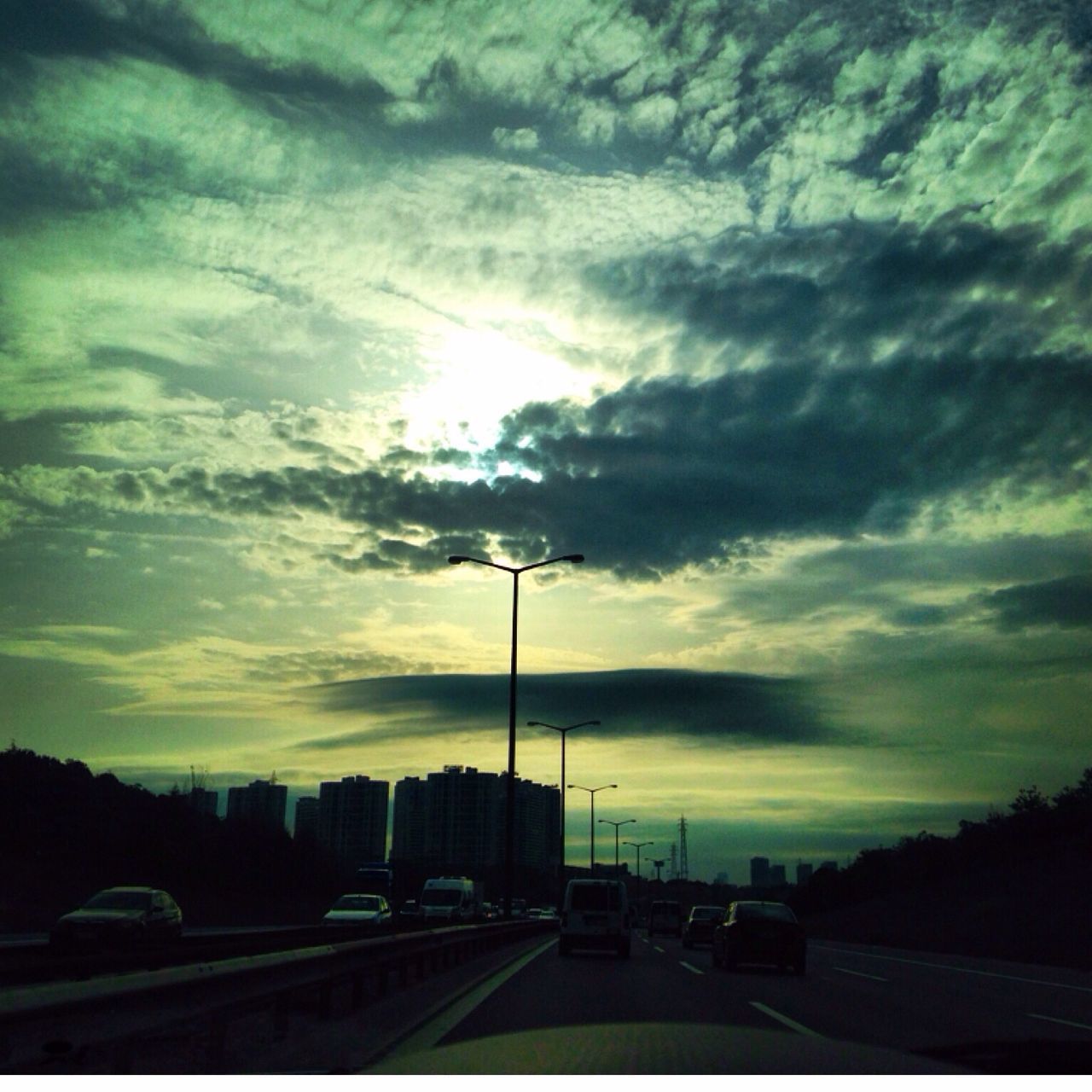 sky, cloud - sky, street light, transportation, car, silhouette, sunset, road, cloudy, street, land vehicle, cloud, mode of transport, dramatic sky, weather, dusk, nature, the way forward, outdoors, overcast