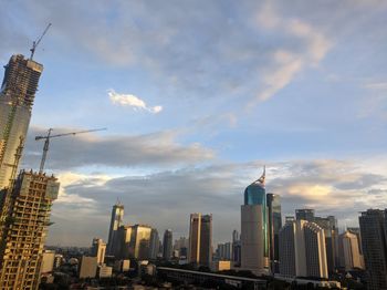 Aerial view of buildings against cloudy sky