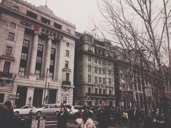 People on street in city against sky