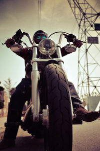 Low angle view of man riding motorcycle on road