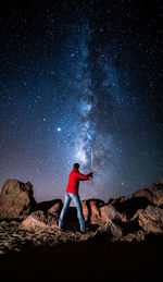 Full length of man standing on rock at night