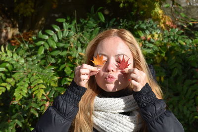 Mid adult woman holding autumn leaves