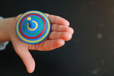 Cropped hand of child holding a handmade wooden whirligig 