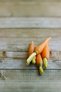Group of baby carrots on defocused wooden background