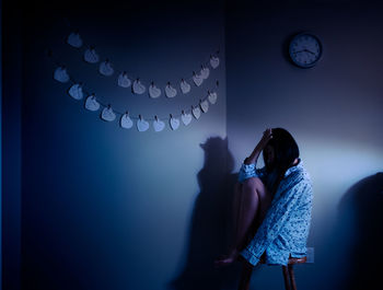 Rear view of woman standing against illuminated lights