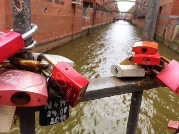 Close-up of padlocks on railing by river