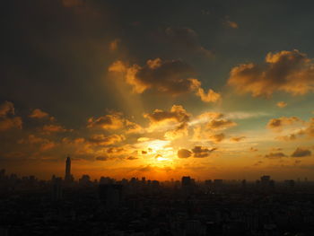 Silhouette cityscape against sky during sunset