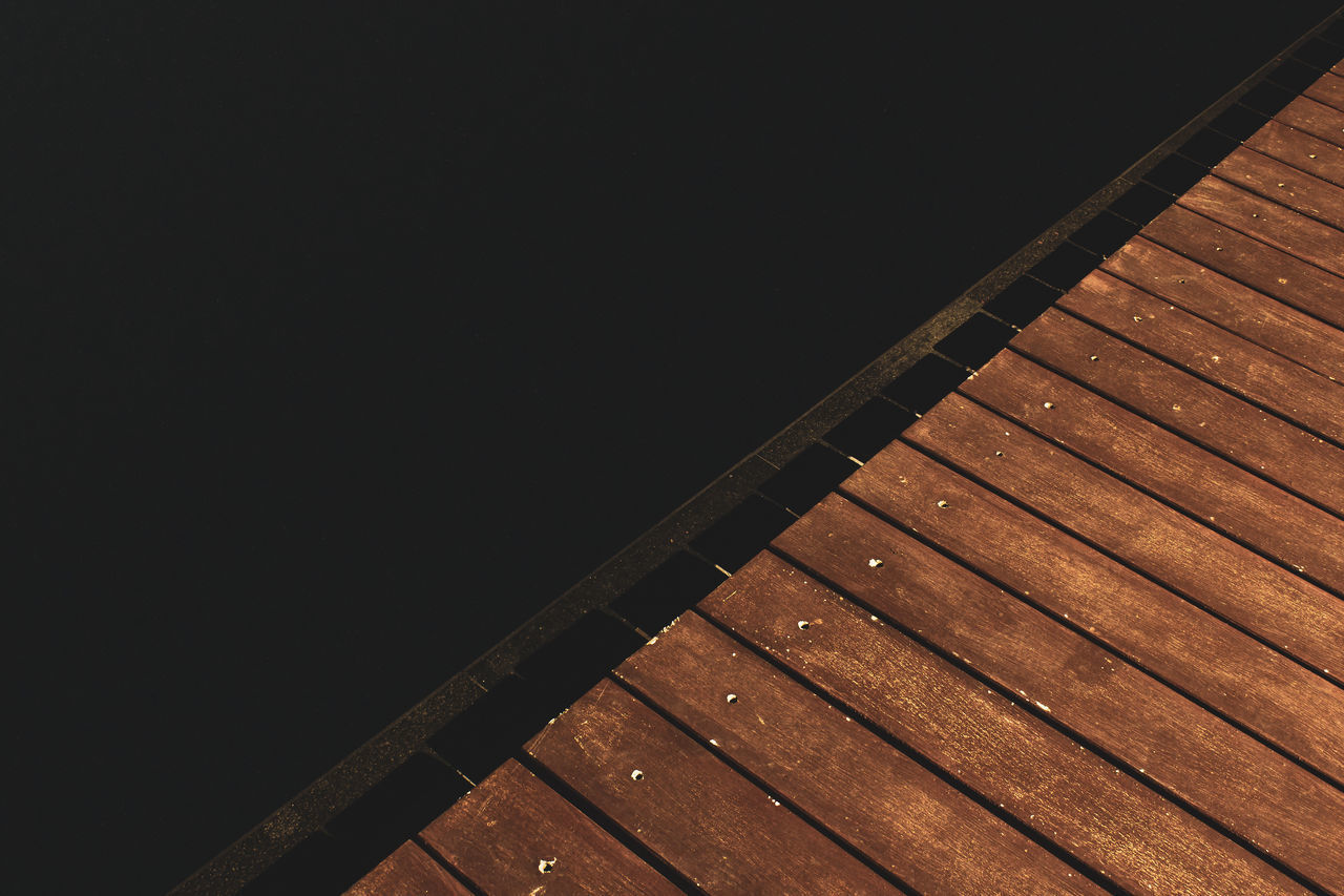 HIGH ANGLE VIEW OF EMPTY PIER OVER SEA AT NIGHT