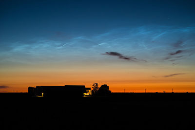 Scenic view of silhouette field against sky during sunset