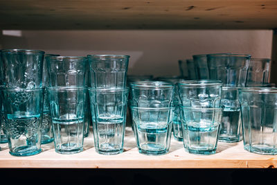 Wooden shelf with green glasses