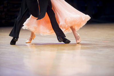 Low section of couple dancing on floor