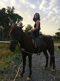 Full length of young woman riding horse