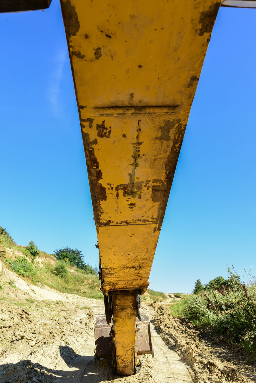 YELLOW ROAD AMIDST FIELD AGAINST CLEAR SKY