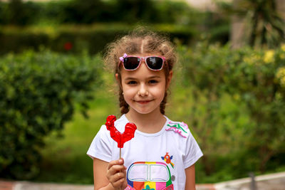 Portrait of young woman wearing sunglasses while standing outdoors