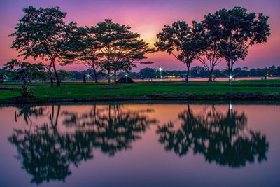 Reflection of trees on lake against sky during sunset