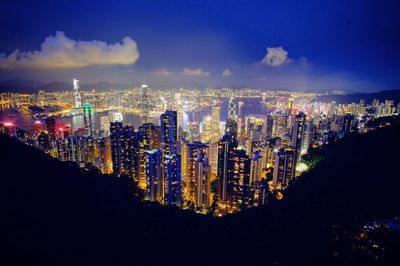 Illuminated cityscape against sky at night