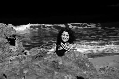 Portrait of young woman standing in sea