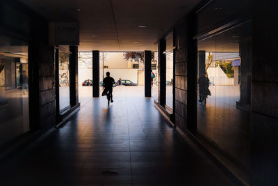 Rear view of silhouette man walking in corridor of building