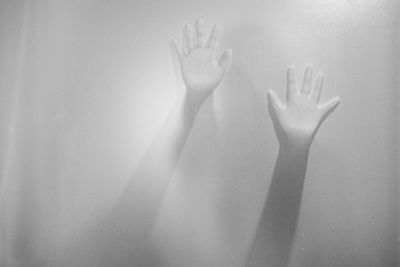 Woman hands seen from frosted glass window