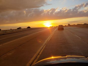 Car on road against sky during sunset